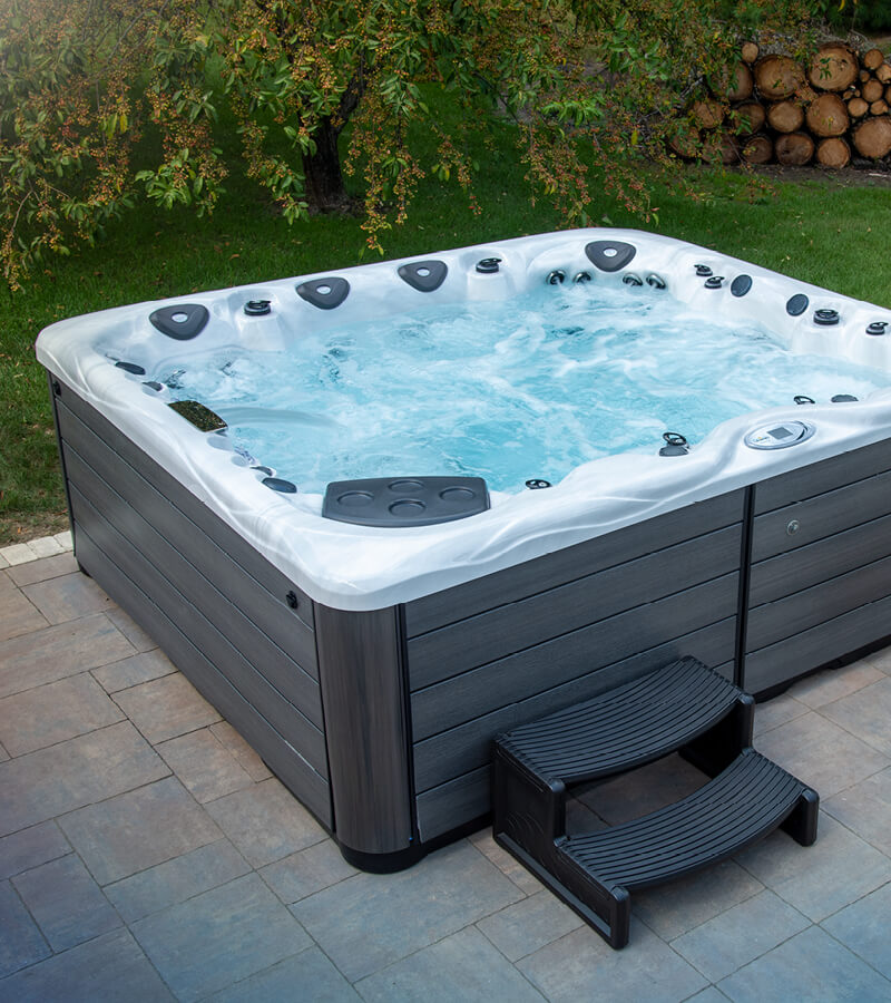 Backyard Hot Tub. When choosing a location for your hot tub, consider the surrounding landscape like trees.